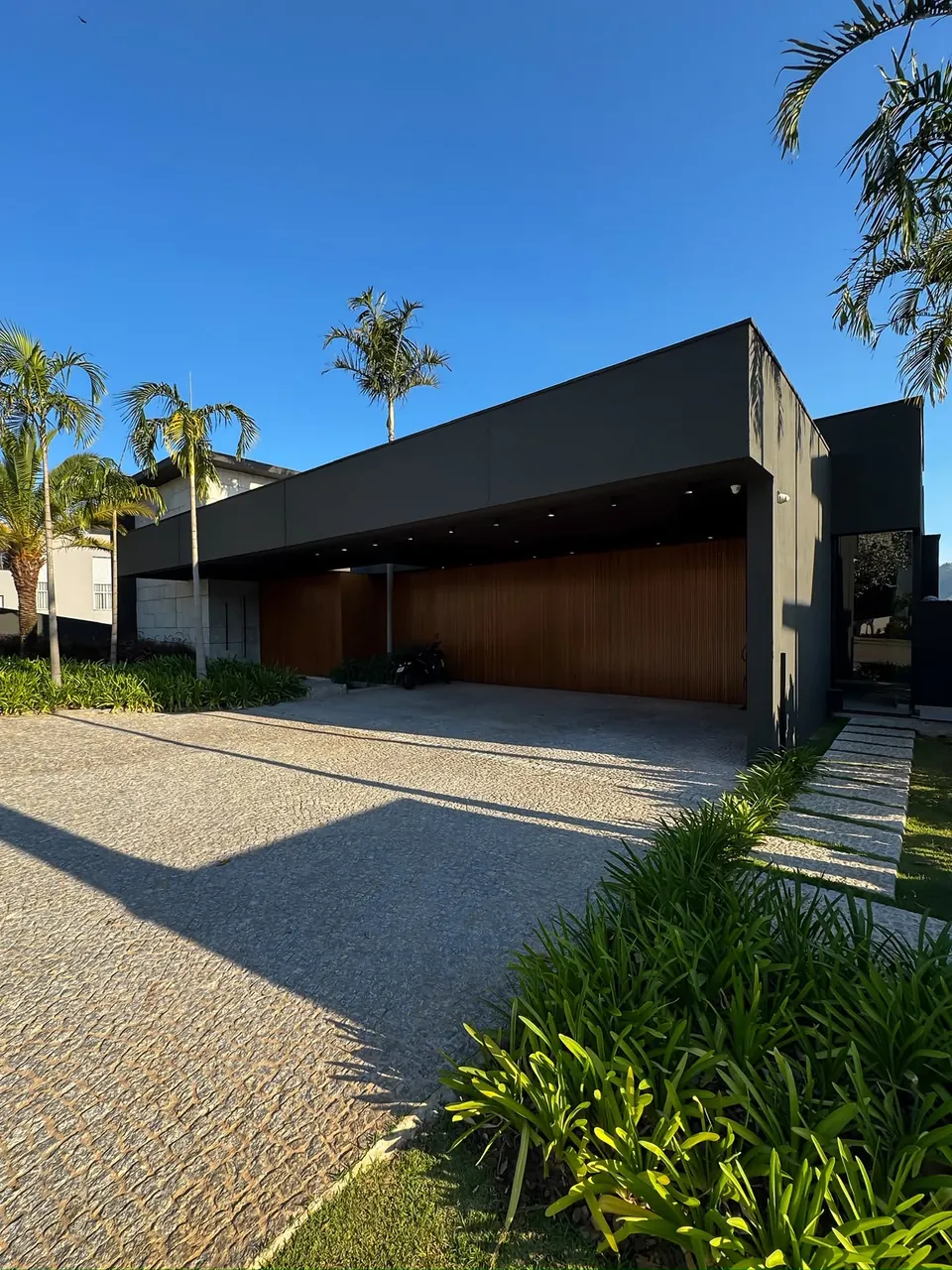 Fachada com garagem coberta e jardim